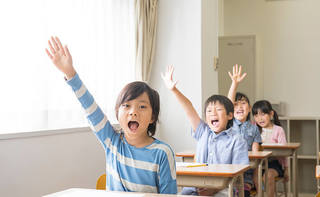 教室で手を挙げている子供の画像.jpg