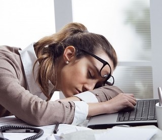 疲れて机の上で居眠りしている女性の画像.jpg
