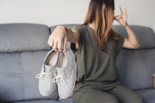 靴を手で持って鼻をつまんでいる女性の画像.jpg